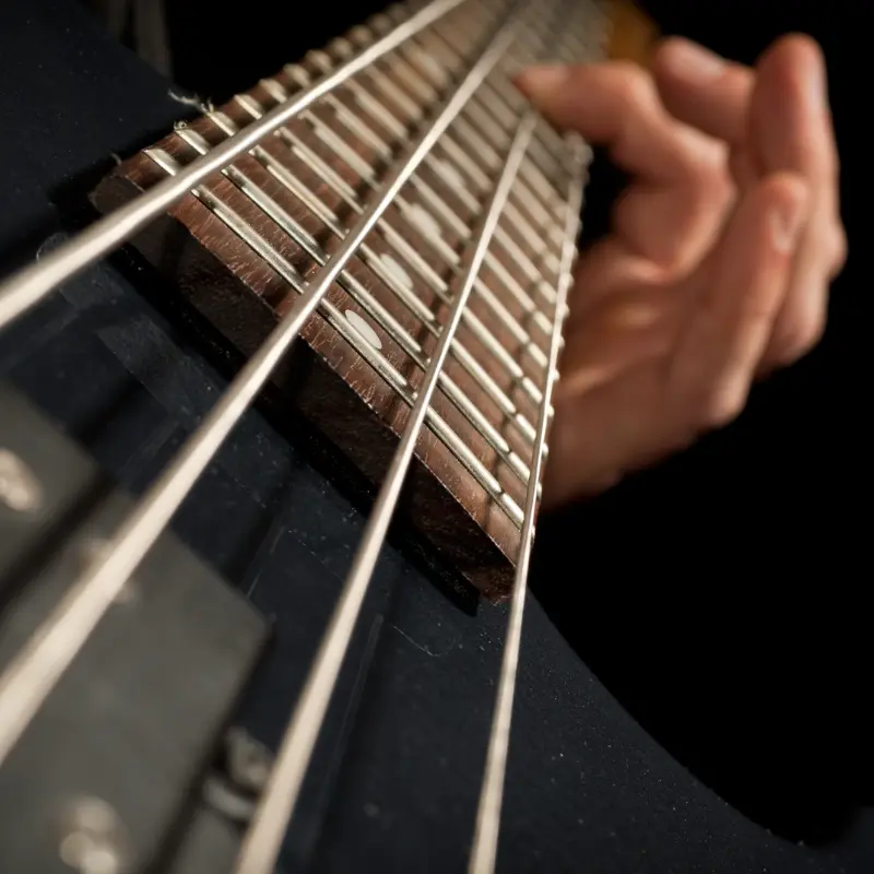 Persona tocando las cuerdas de un bajo